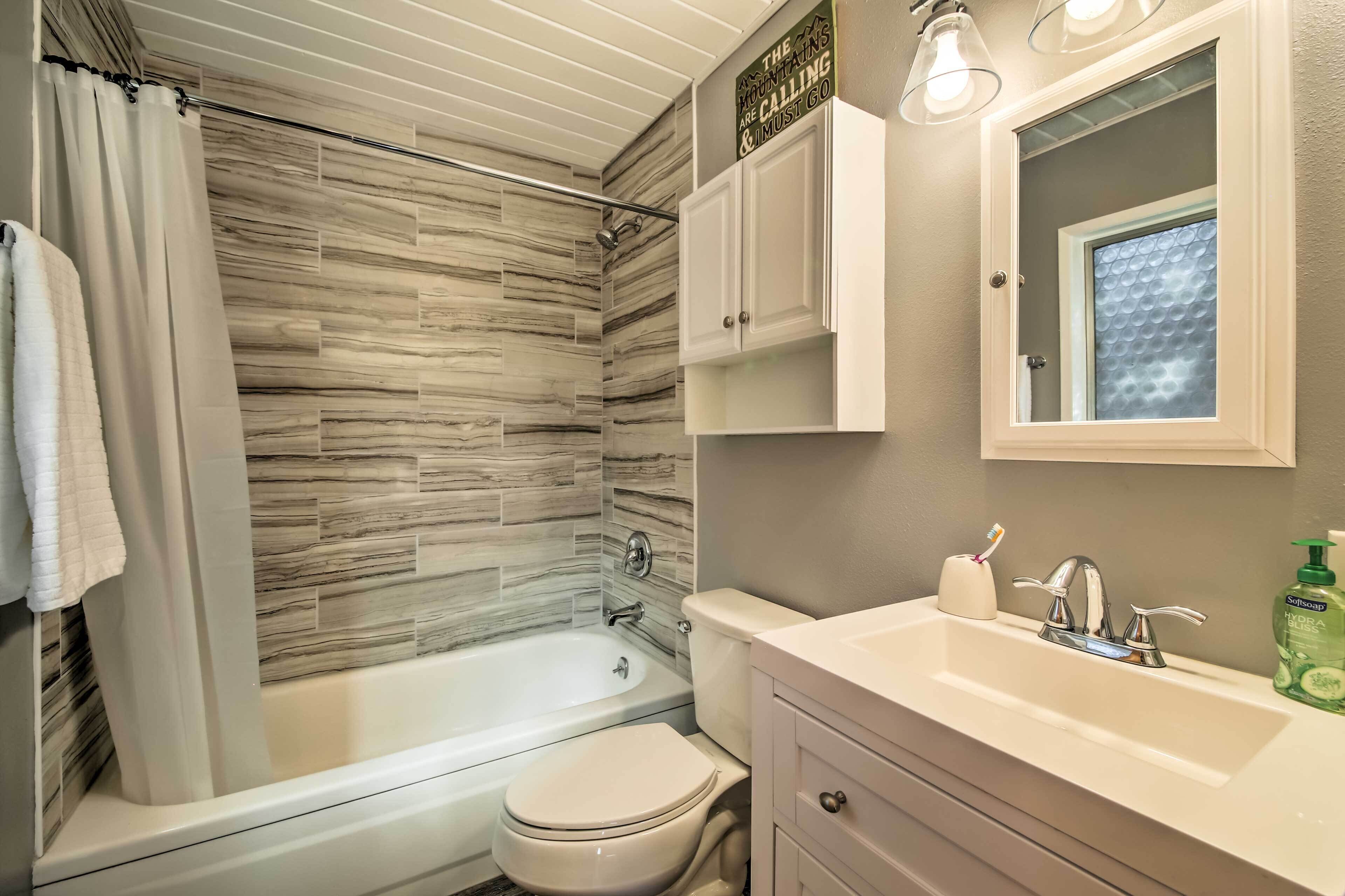 A bathroom with a bathtub, toilet, and sink.