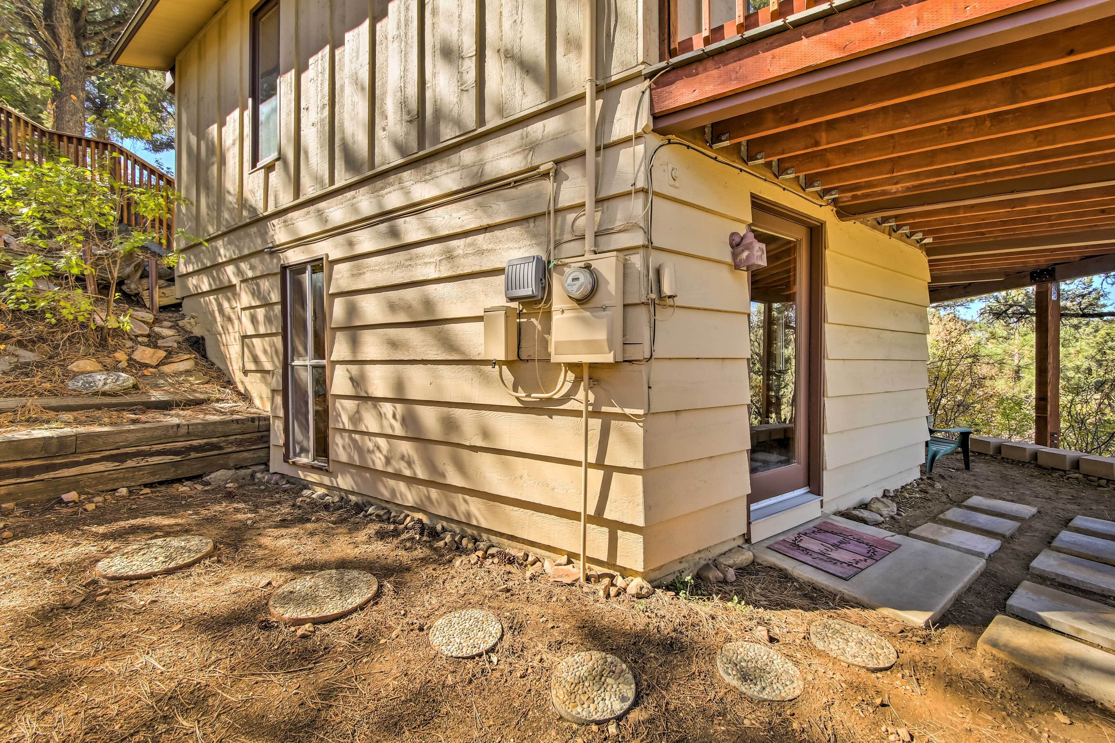 Una casa con facciata in legno, un portico coperto e un vialetto in pietra che conduce all'ingresso.
