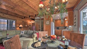 A cozy living room with a wooden ceiling, a glass coffee table, and a fireplace. - Mountainside Cabin w/ Deck - 16 Miles to Skiing! (Lake Arrowhead)