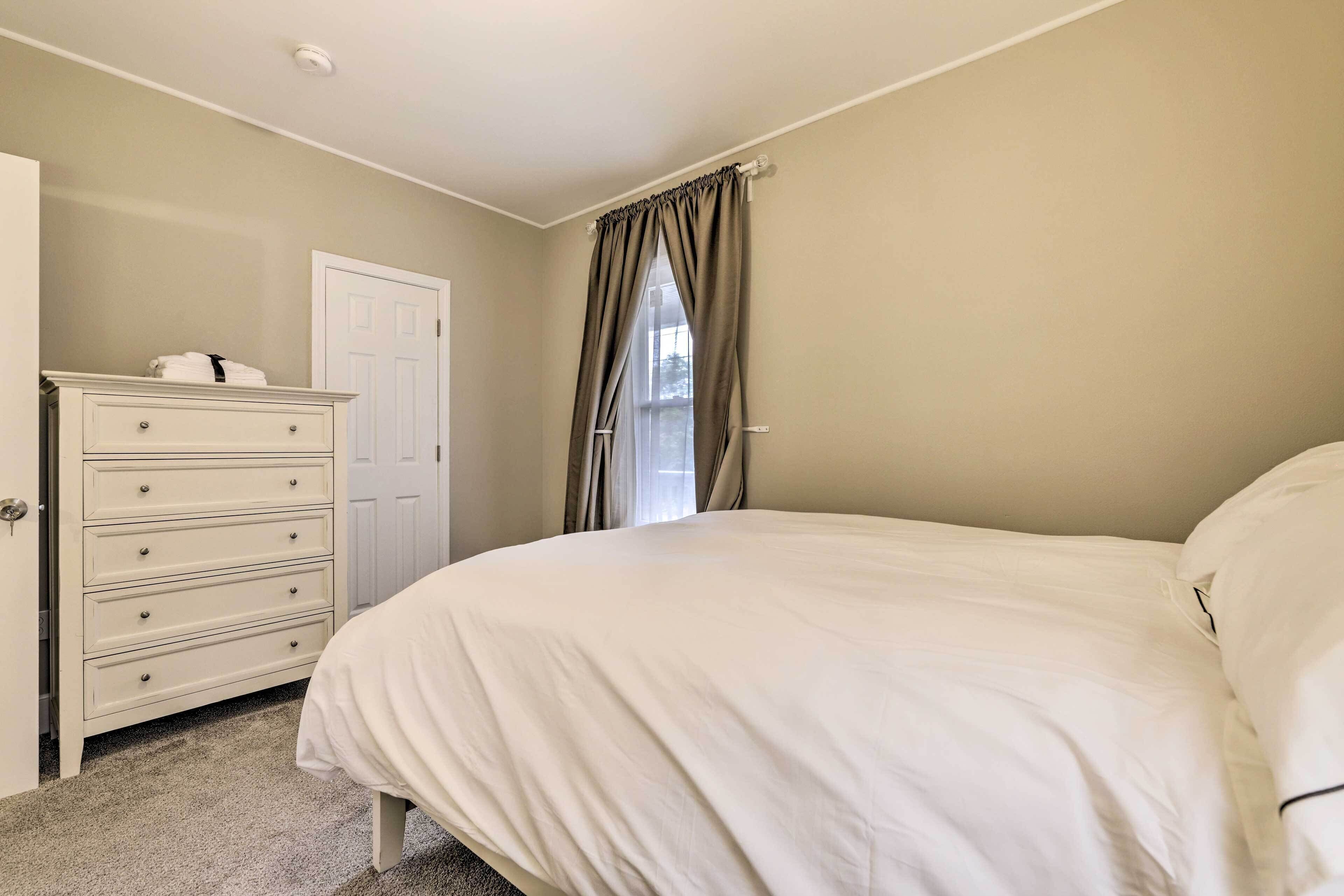 Een slaapkamer met een bed, een kaptafel en een deur.