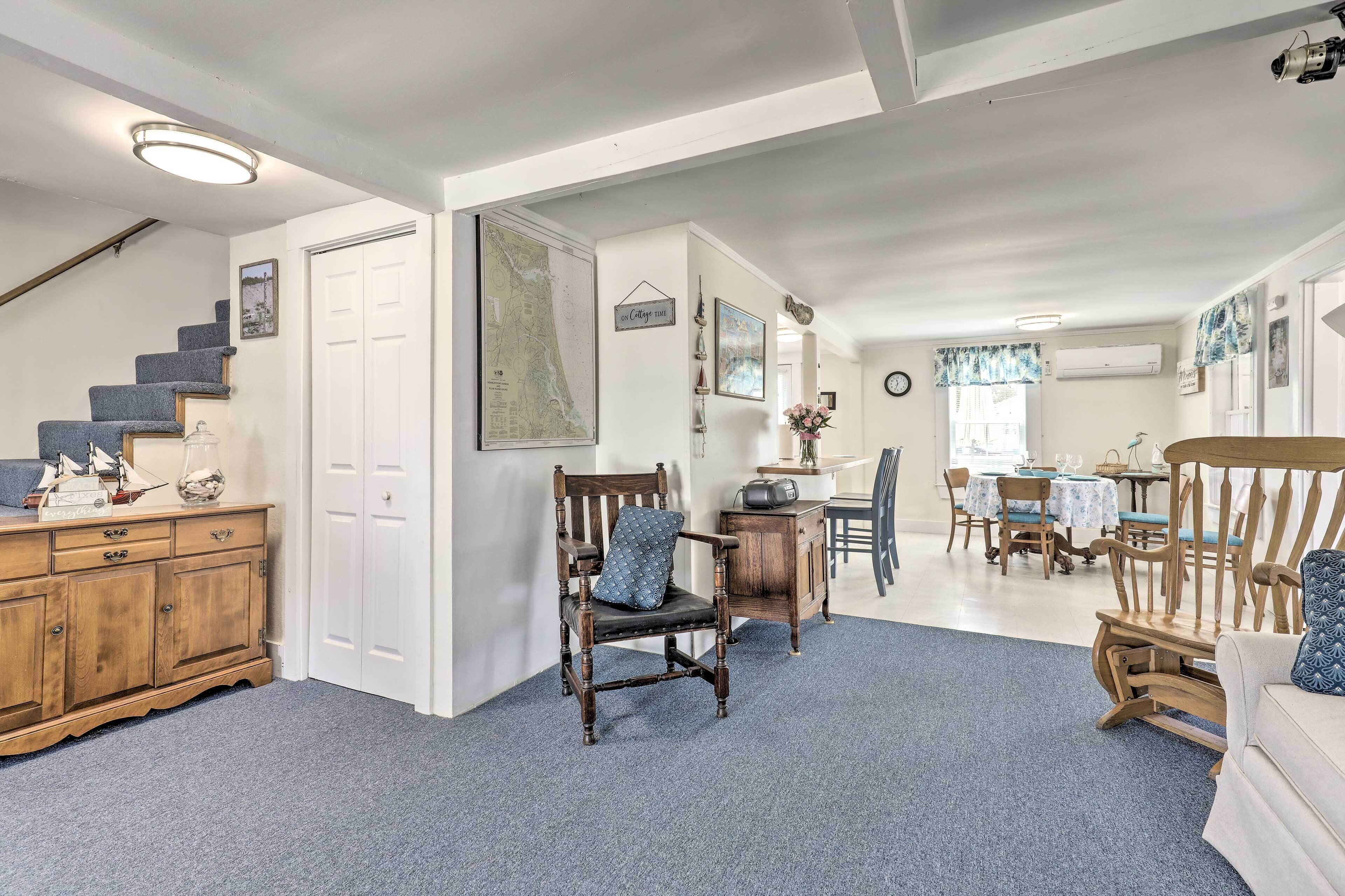 A spacious living area with a staircase, wooden furniture, and a dining area with a table and chairs.
