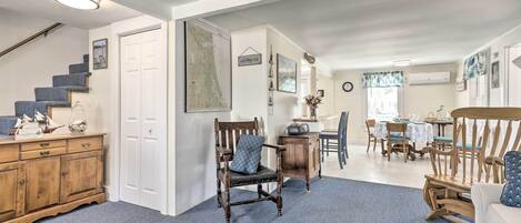 A spacious living area with a staircase, wooden furniture, and a dining area with a table and chairs.