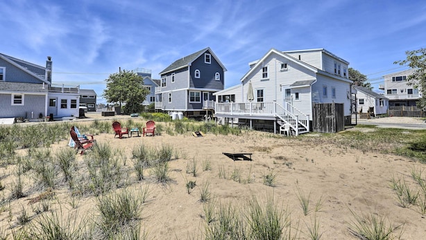 A beachfront property with multiple houses, a sandy beach, and a small dock. - Plum Island Retreat ~ 1-block Walk to Beach! (Newbury)