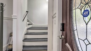 Un escalier menant à une pièce dont la porte est dotée d’un panneau de verre et d’un autocollant.