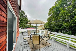 Una terraza de madera con muebles de exterior y un gran paraguas.