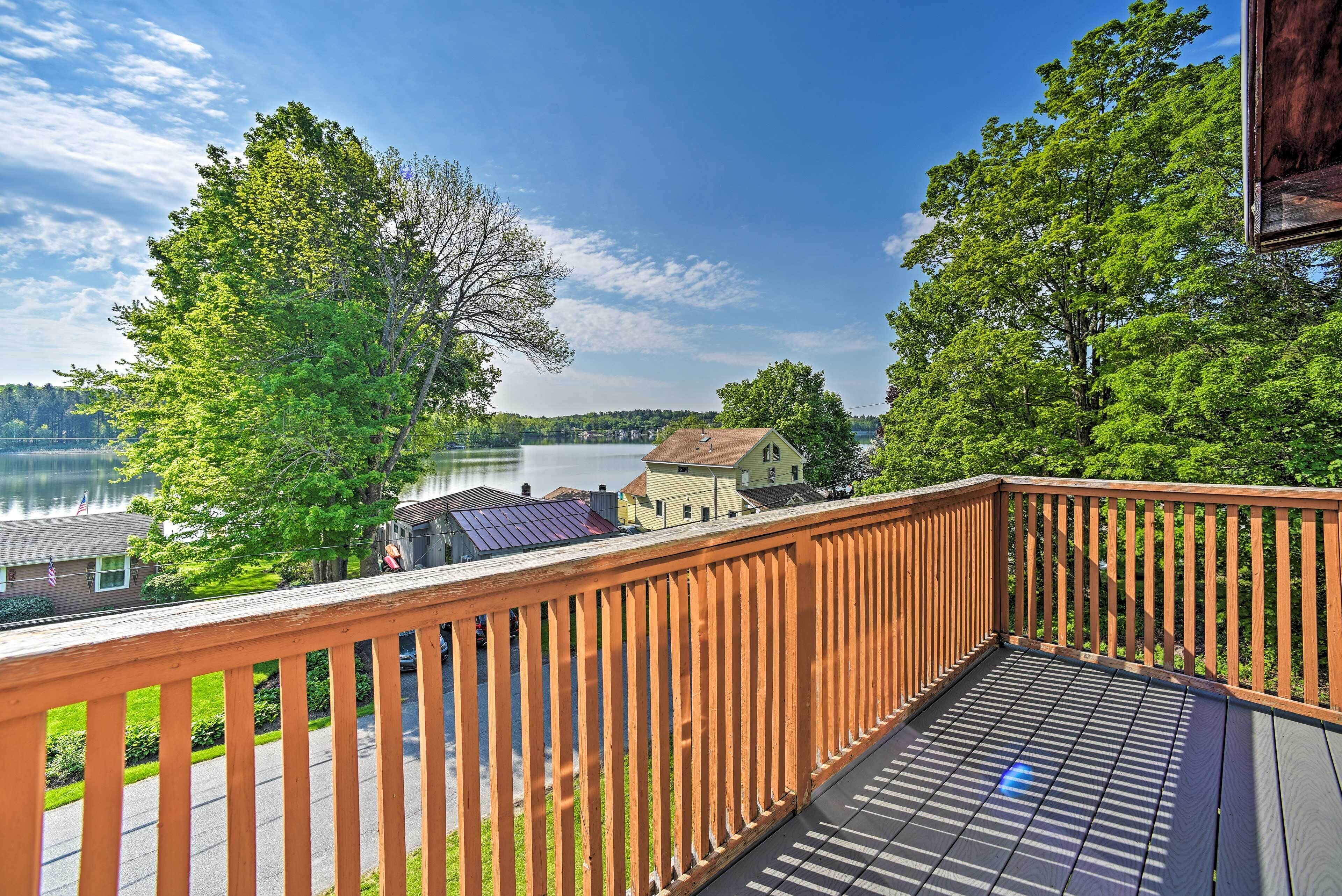 A wooden deck with a view of a lake and houses.