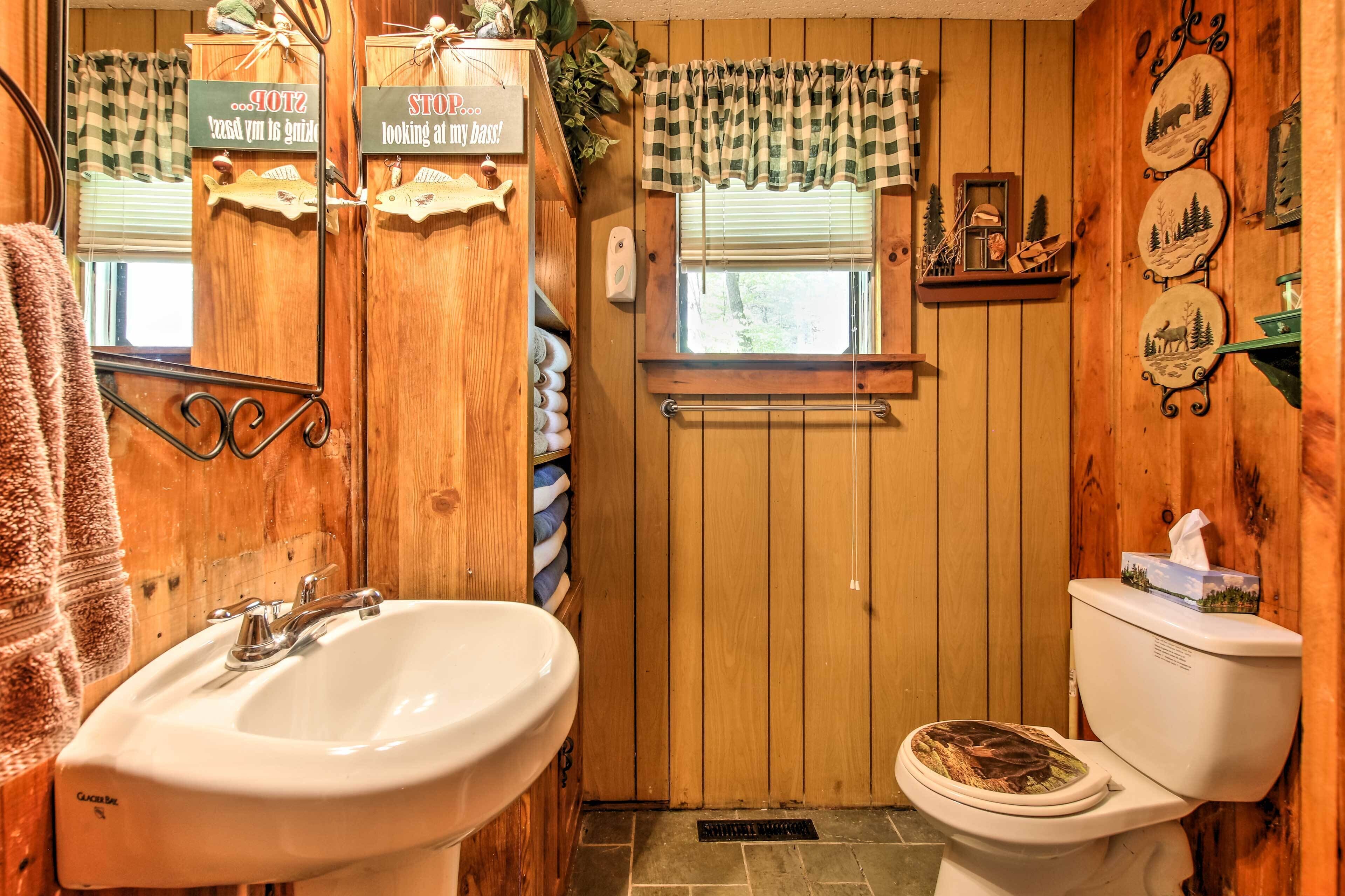 A wooden bathroom with a sink, toilet, and towel rack.
