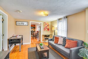 A living room with a sofa, coffee table, and a pool table. There is a kitchen in the background. - Stunning Brockton Apt < 4 Mi to Westgate Mall! (Brockton)