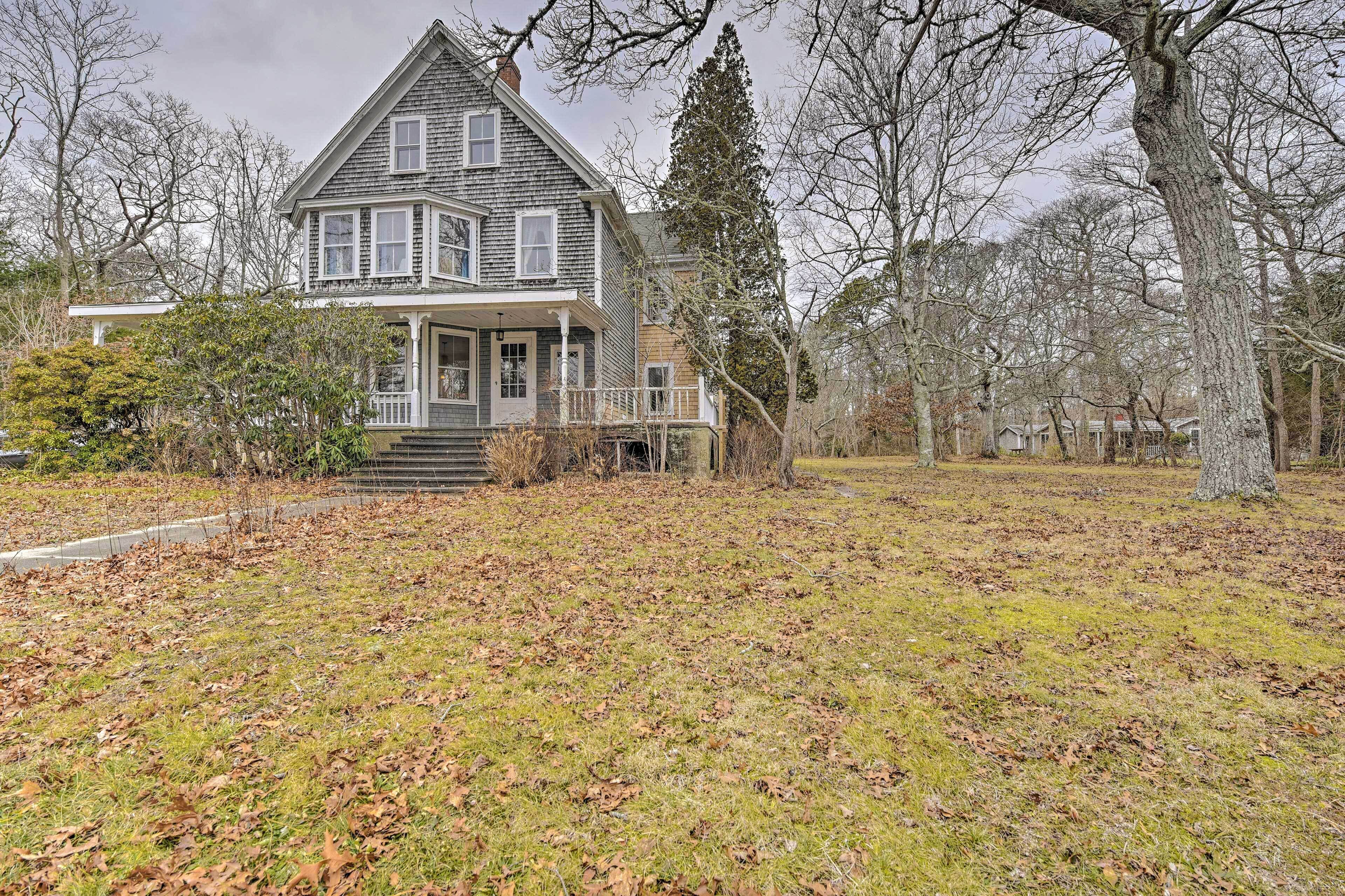 A two-story house with a porch and a front yard.