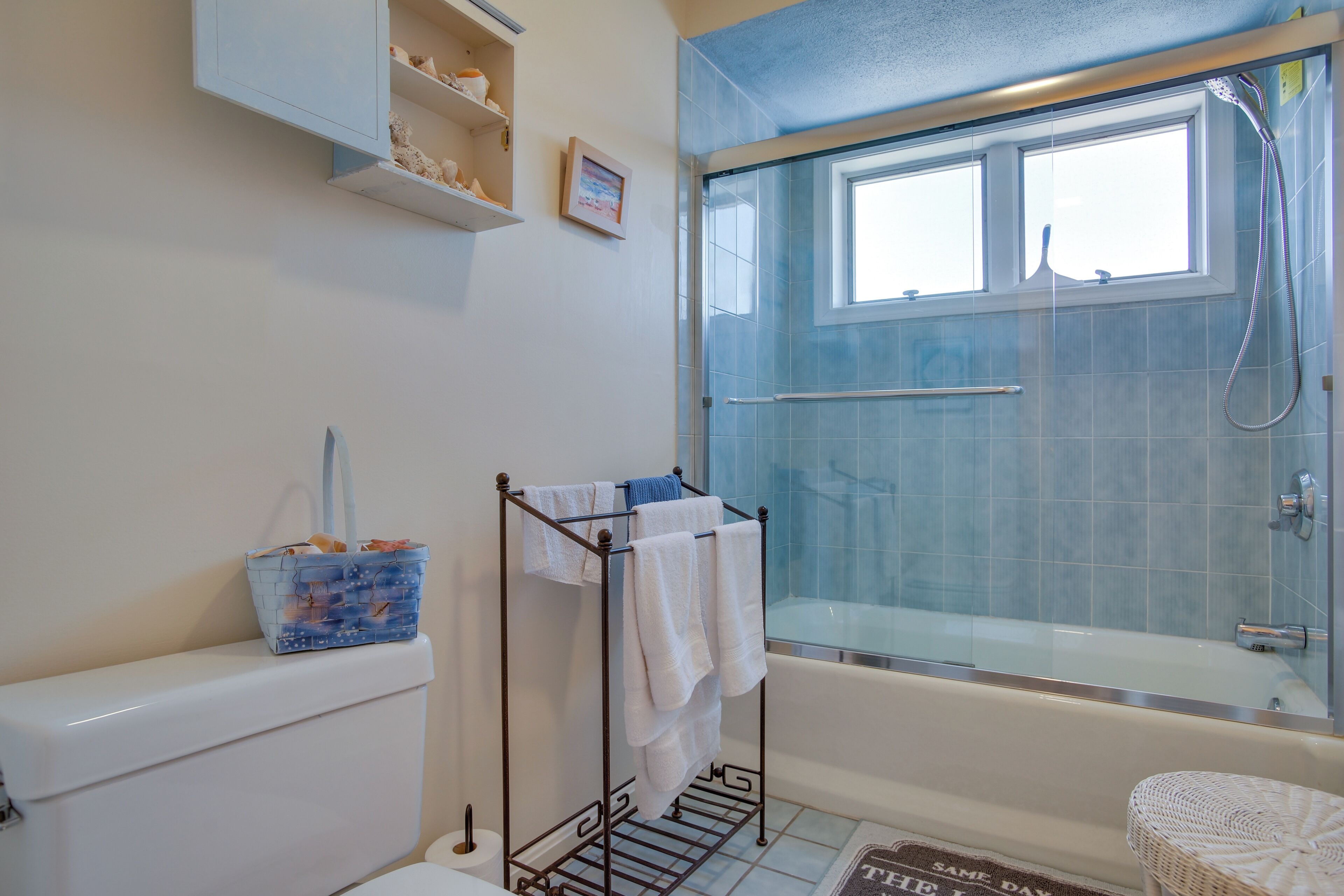 A bathroom with a glass-enclosed shower, a bathtub, and a toilet.