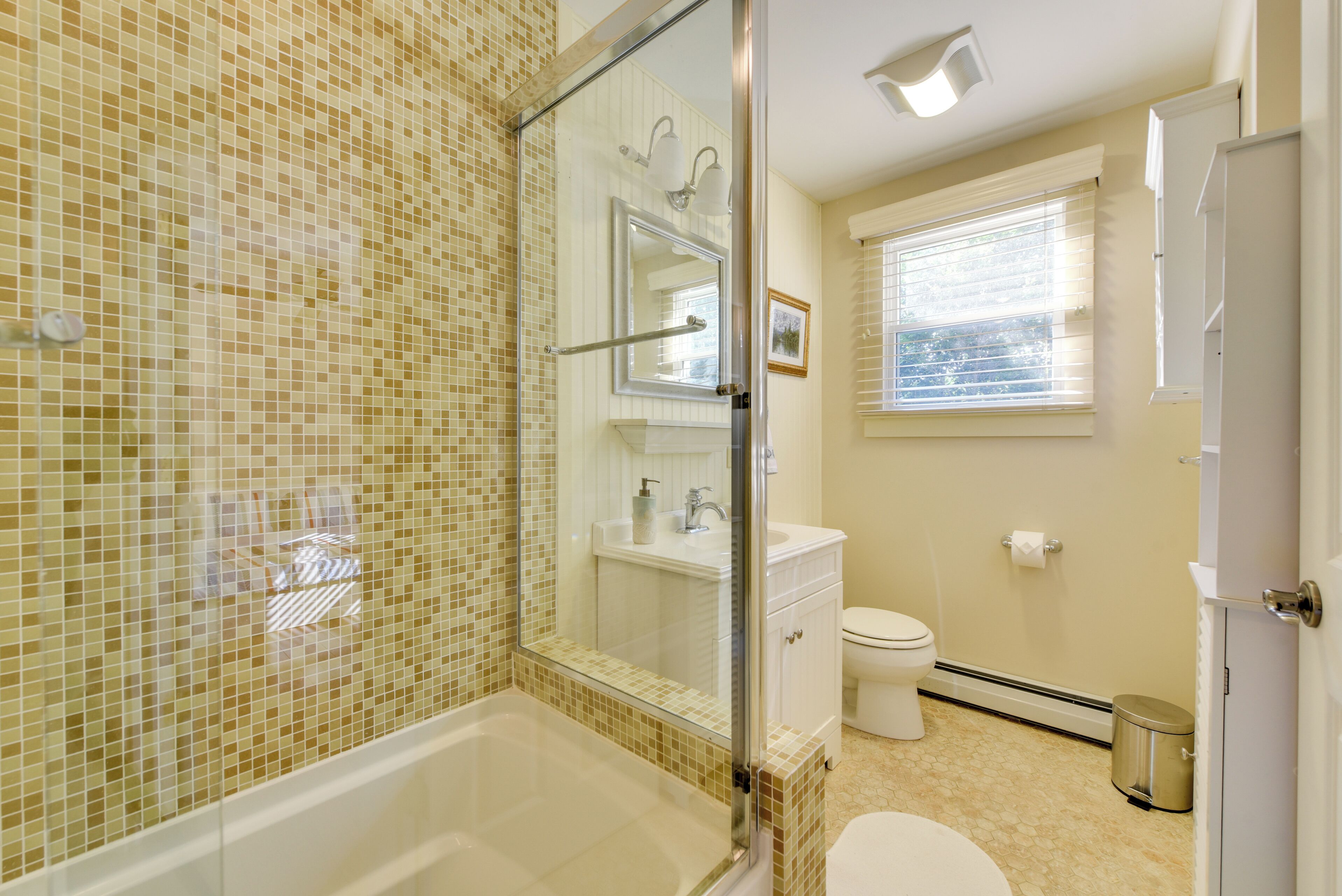 Une salle de bain avec une douche à parois de verre, des toilettes blanches et un lavabo.