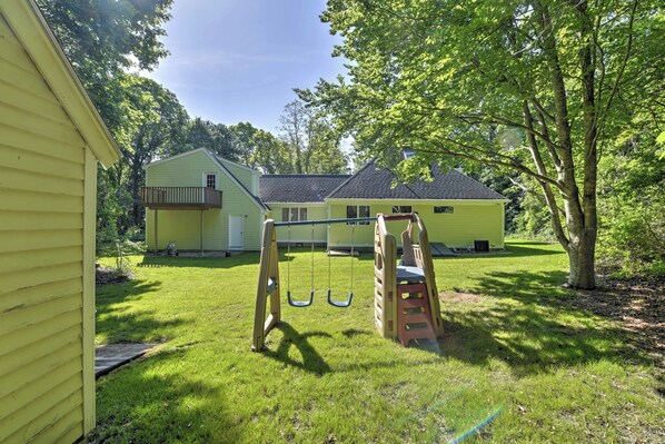 A residential property with a swing set, a small deck, and a well-maintained lawn. - Families Welcome! East Falmouth Home 4 Mi to Beach (East Falmouth)