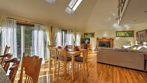 A spacious living room with a wooden dining table, comfortable seating, and a fireplace.