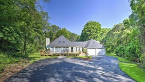 A two-story house with a covered porch, a driveway, and a well-maintained lawn.