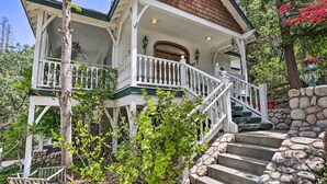 A two-story house with a porch, stone steps, and a wooden staircase. - Ornate Lake Arrowhead Home With Deck (Lake Arrowhead)