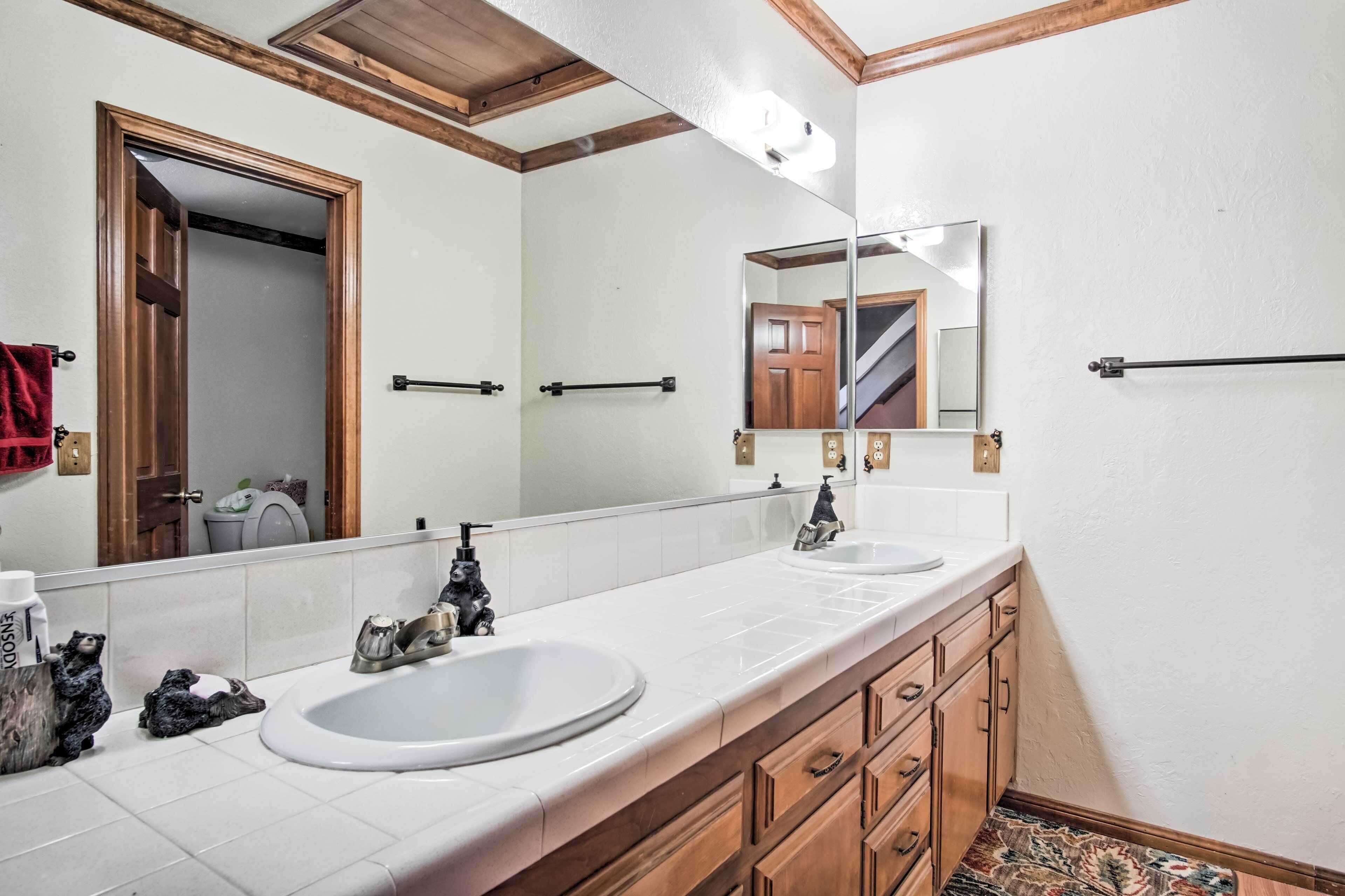 A bathroom with two sinks, wooden cabinets, a large mirror, and a wooden ceiling.