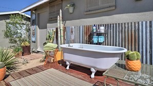 A bathroom with a freestanding bathtub, a metal table, and potted plants. - 'rockview House' 5 Mi to Joshua Tree Nat'l Park! (Joshua Tree)