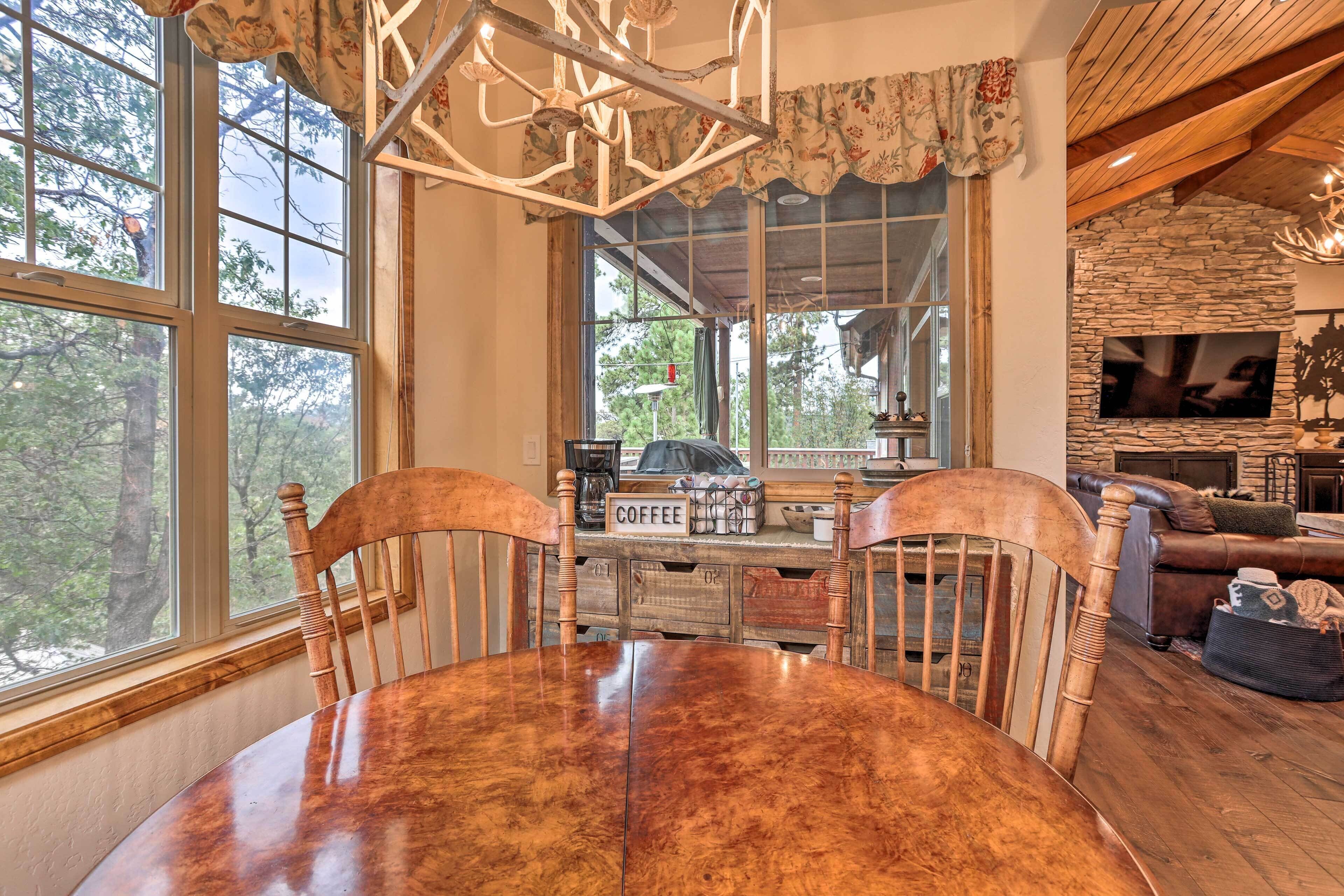 Un comedor con mesa y sillas de madera, una estación de café y una chimenea de piedra.
