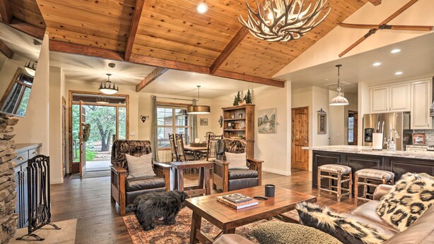 A spacious living room with a fireplace, leather furniture, and a large wooden ceiling. - Near Bear Mountain & Big Bear Lake: Gem w/ Hot Tub (Big Bear City)