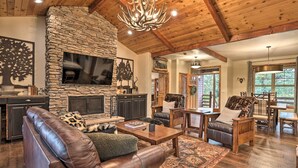 A spacious living room with a stone fireplace, leather furniture, and a wooden ceiling. - Near Bear Mountain & Big Bear Lake: Gem w/ Hot Tub (Big Bear City)
