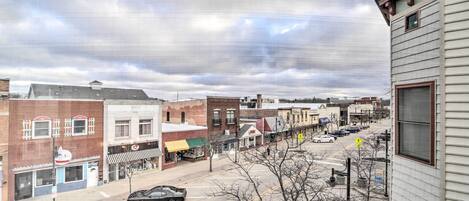 A street view with buildings, a road, and a parked car.