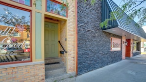 A building with a brick facade, a green door, and a sign that reads "Taste."