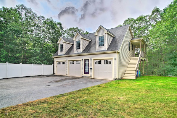 A two-story house with a garage, a covered porch, and a fenced backyard.