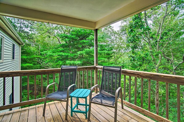 A wooden deck with two chairs and a small table, overlooking a forested area. - 3 Mi to Beaches: Tranquil Cape Cod Escape w/ Deck (Buzzards Bay)