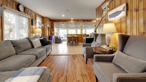 Una sala de estar acogedora con un sofá, un sillón y un comedor con mesa y sillas.