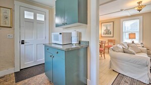 Un espace de vie compact comprenant une kitchenette, un coin repas et une chambre.