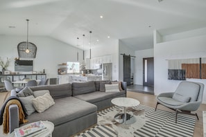 A modern living room with a grey sofa, a round coffee table, and a patterned rug.