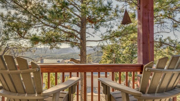 A wooden deck with two Adirondack chairs facing a mountainous landscape. - Wildlife Watching & Mtn Views: Luxe Ruidoso Escape (Ruidoso)