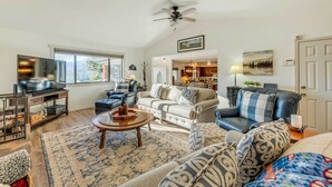 A spacious living room with a large TV, comfortable seating, a ceiling fan, and a view of the outdoors. - Wildlife Watching & Mtn Views: Luxe Ruidoso Escape (Ruidoso)