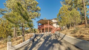 A two-story house with a balcony, surrounded by pine trees. - Wildlife Watching & Mtn Views: Luxe Ruidoso Escape (Ruidoso)