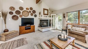 Un salón amplio con chimenea, televisor y un rincón de estar acogedor.