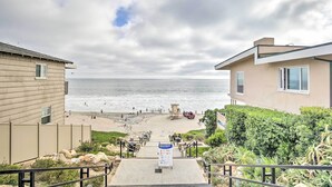 A beach view from a building with a sign indicating beach rules. - Coastal Carlsbad Home: 1 Mi to Beach & Downtown (Carlsbad)