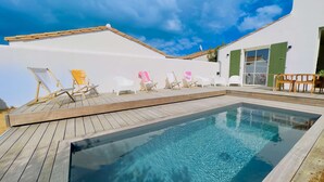 A swimming pool with wooden decking and lounge chairs. - Luxury villa with swimming pool for 8 people (LA COUARDE SUR MER)