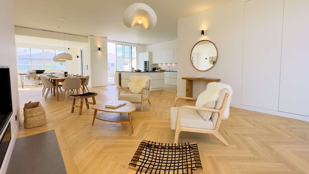 A modern living room with a dining area, kitchen, and large windows. - Luxury villa with swimming pool for 8 people (LA COUARDE SUR MER)