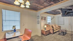 A cozy living room with a wooden ceiling, a sofa, a coffee table, and a TV mounted on the wall. - Hot Springs Home: 2 Mi to Hot Springs Nat'l Park (Hot Springs)