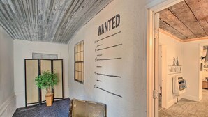 A room with a 'WANTED' poster on the wall, a potted plant, a suitcase, and a radiator. - Hot Springs Home: 2 Mi to Hot Springs Nat'l Park (Hot Springs)