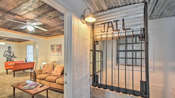 A living room with a brown sofa, a coffee table, and a ceiling fan. - Hot Springs Home: 2 Mi to Hot Springs Nat'l Park (Hot Springs)