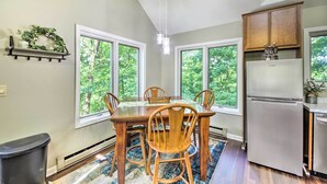 A dining area with a wooden table and chairs, a chandelier, and a refrigerator. - Peaceful Nashville Hideaway Near State Parks! (Nashville)