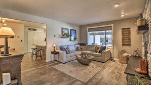 A cozy living room with a sectional sofa, a coffee table, and a fireplace. There is a kitchen in the background and a dining area with bar stools. - 2 Mi to Rocky Mtn Nat'l Park: Grand Lake Condo (Grand Lake)