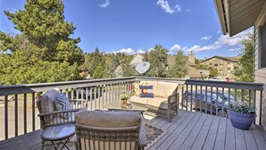 A wooden deck with outdoor furniture, a large potted plant, and a view of a residential area with houses and trees. - 2 Mi to Rocky Mtn Nat'l Park: Grand Lake Condo (Grand Lake)