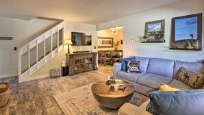 A living room with a staircase, a flat-screen TV, a sofa, and a coffee table. - 2 Mi to Rocky Mtn Nat'l Park: Grand Lake Condo (Grand Lake)