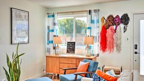 A cozy living room with a wooden desk, a blue armchair, and a sofa. There is a potted plant and a map on the wall. - < 4 Mi to Dtwn Palm Springs: Home w/ Private Patio (Palm Springs)