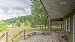 Une terrasse en bois offrant une vue sur un terrain de golf et des arbres.