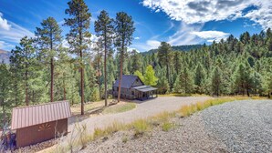 A rustic cabin surrounded by a forest with a clear sky. - Jemez Springs Cabin w/ Stunning Mtn Views! (Jemez Springs)