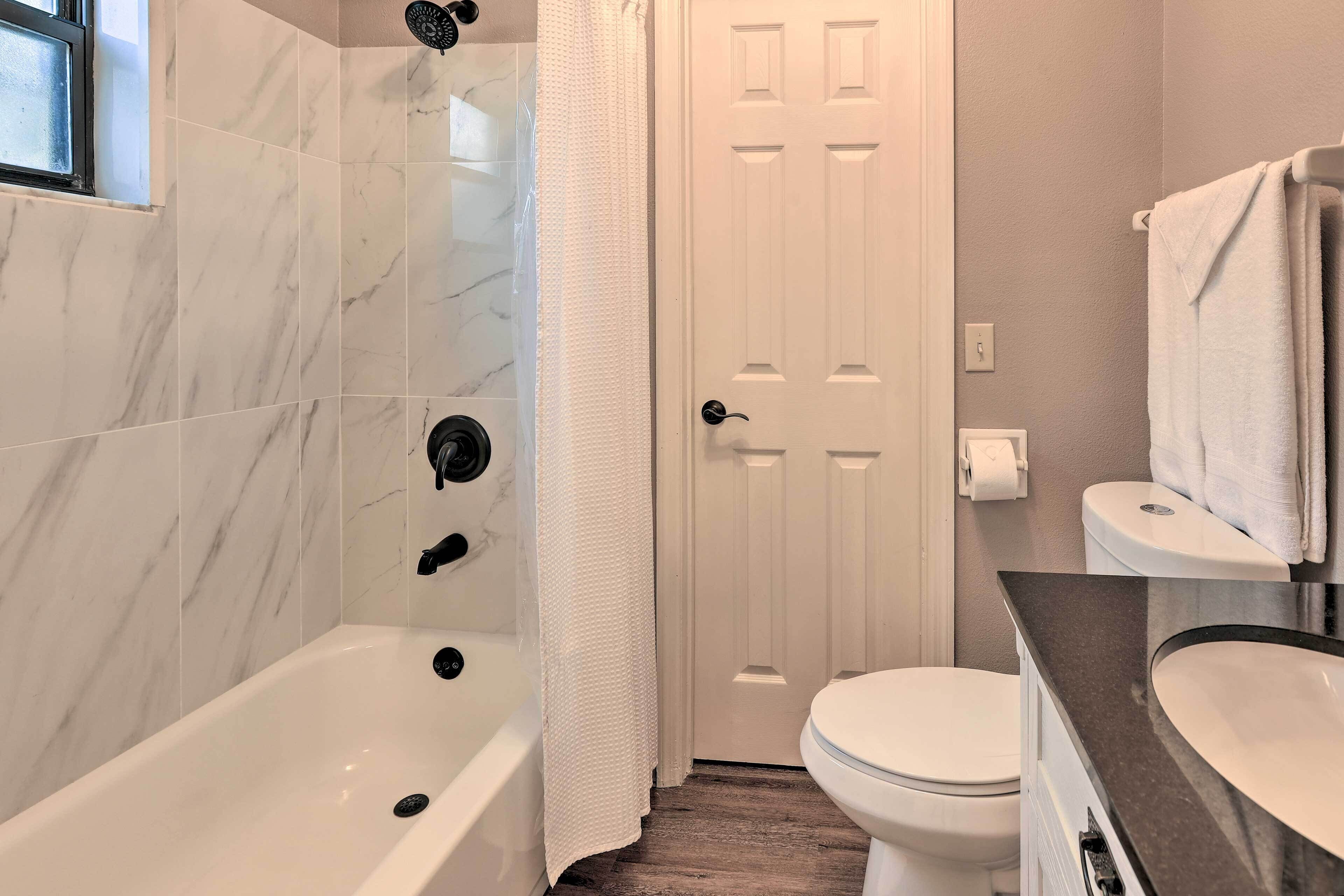 Un baño con bañera, inodoro y lavabo.