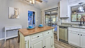 A kitchen with white cabinetry, a wooden countertop, a ceiling fan, and a dishwasher. - Charming Ocala Home Near World Equestrian Center! (Ocala)